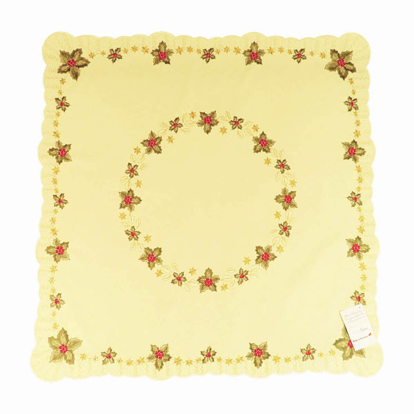 Square champagne color table cloth, with a circle of holly leaves and Christmas stars in the center, and a border of holly leaves and stars around the edges.