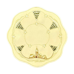 Round champagne color table linen with scalloped edges. Outer border design of snow covered church and trees, with alternating star designs in between. Interior border is a design of golden threading with stars.