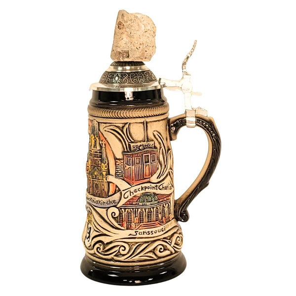 side of 0.25L German beer stein with Berlin landmarks Checkpoint Charly, Sanssouci in relief, and pewter lid featuring a real Berlin Wall fragment.