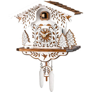 Image of Engstler Quartz Chalet Cuckoo Clock, featuring a white clock with a brown roof and intricate brown ornaments. A white bench sits in front, surrounded by trees with brown details. The pendulum and weights are white with brown accents.