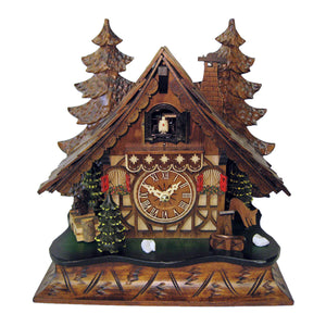 Image of Engstler Quartz Black Forest Mantel Cuckoo Clock, depicting a quaint half-timbered house with red shutters, surrounded by two tall trees. A squirrel sits atop a stack of wood on one side, while a deer grazes beside a well on the other.
