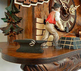 A blacksmith standing between an Anvil and a forge next to the dial of a Schneider cuckoo Clock