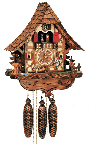 8-Day Black Forest Chalet Schneider coocoo clock with music. The chalet is white with curved brown timbers. A green fir tree sits on each side. On the left, a water well sits next to a water wheel, the little brook is lined with stones. On the right, there is a stag behind a fence, and a boy and a girl are seesawing on a teeter-totter in the middle underneath the dial. The two windows have red shutters and flower boxes underneath. Dancers spin above an ornate balcony. The roof has shingles.