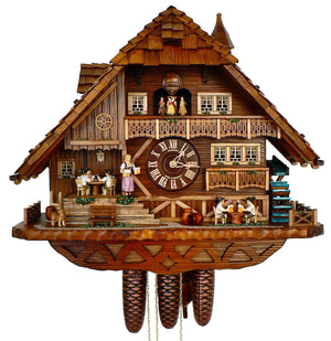 8-Day Schneider Coocoo clock with music. On the lowest level of this multi-level clock, a fenced in water wheel spins on the right. Two men are drinking beer at a table, a dog is guarding a keg on the left. On the next level up, a waitress is about to walk down stairs, carrying beer steins and a group of men are playing cards at a table in the corner behind her. A large window with balcony sits to the right of dial and dancers spin on the wide top balcony. The shingled roof has a dormer window and a turret.