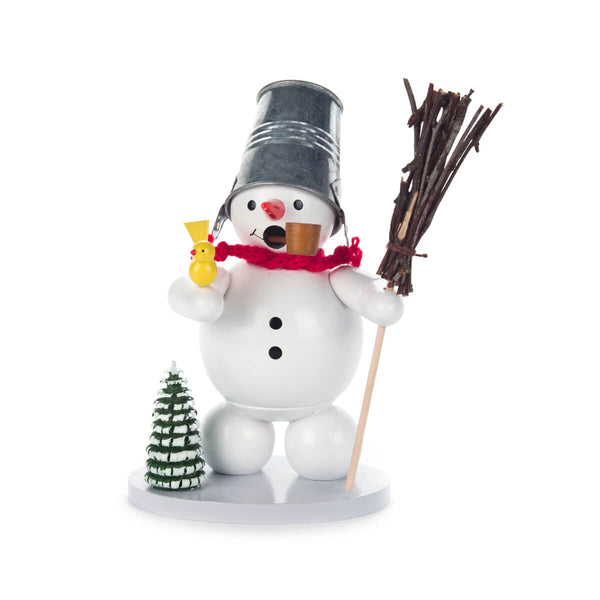 This charming holiday decoration features a snowman dressed in a bucket hat and red scarf. E is holding a broom in his left hand and a cheerful yellow bird sits on top of his right hand. There is a little green, snow-covered tree by his right foot. He is happily smoking his pipe.
