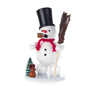 This finely crafted Dregeno Smoker from Germany is sure to bring a touch of whimsy to your holiday décor. Hand-carved out of wood and hand-painted, it depicts a cheerful snowman sporting a red scarf and a top hat and holding a broom in one hand, with a little green snow-covered tree and bunny at his side. The snowman smoker is happily smoking his pipe. Add a unique accent to your home with this beautiful piece.