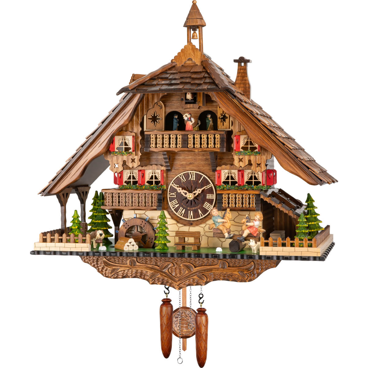 This hand-carved battery-operated Black Forest cuckoo clock features a boy and a girl on a teeter-totter on the right, watched over by a puppy dog. There is a bench underneath the clock dial, and a St. Bernard wearing a keg on the left by pine trees. The sides of the base platform and the front corners are fenced in. There are two balconies on either side of the clock dial and a wide balcony above the dial where the dancers spin to the music. A bell tower adorns the top of the shingled roof.