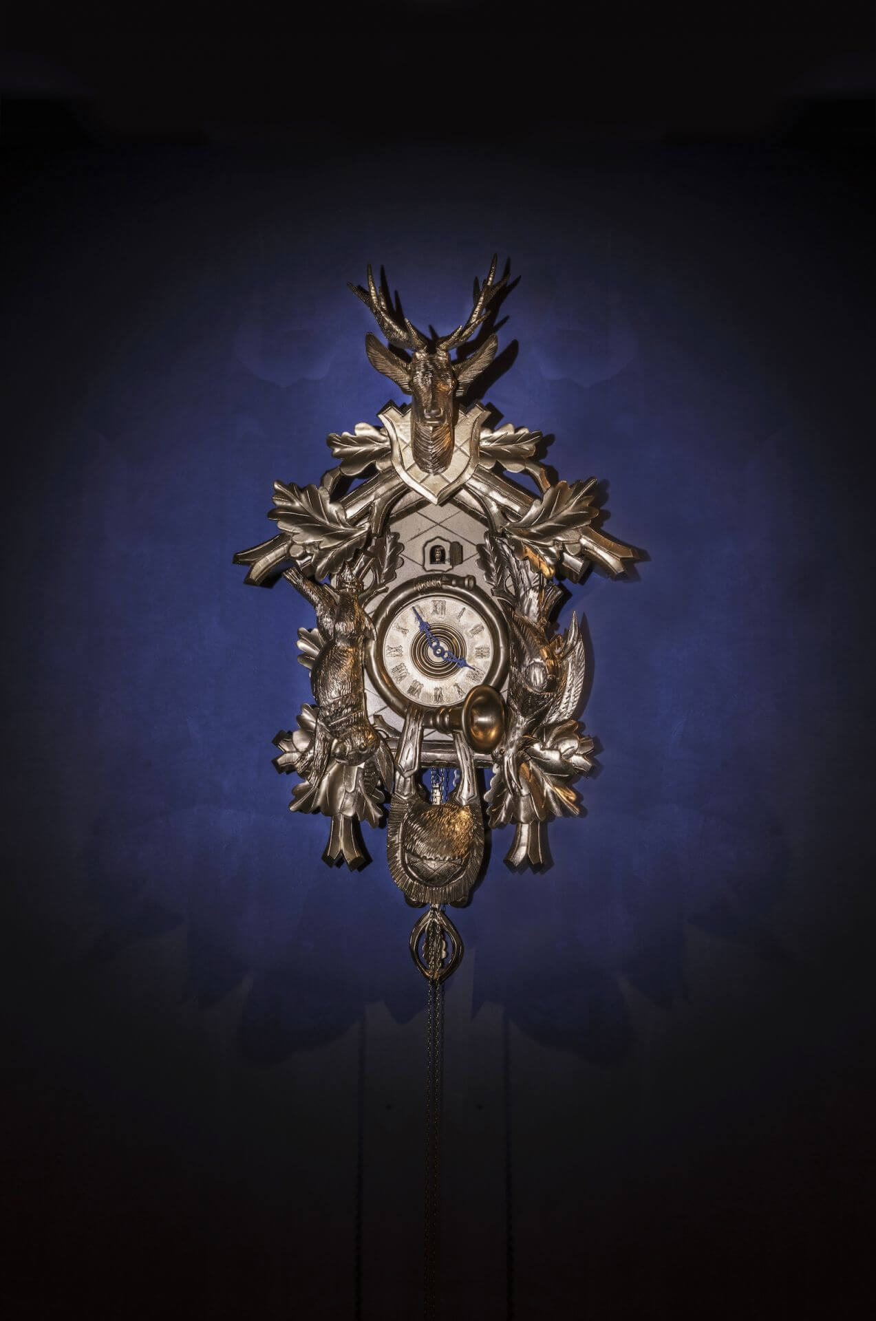 Traditional clock with antique-style clock dial on royal blue background.