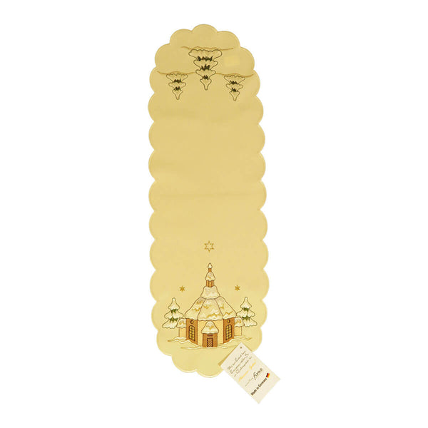 Cream color table runner with design of snow covered forest on one end, and a church with stars above on the other.