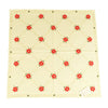 Square white tablecloth with repeating crosshatch design of red poinsettias with leaves.