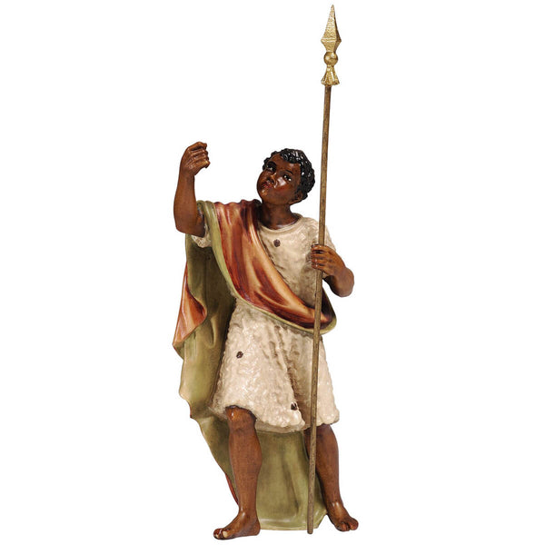 The figurine is carved out of maple wood. The black male camel driver is wearing a white dress with black dots, a reddish cape is slung over his right shoulder.  He is holding his staff in his left hand and the right hand is carved to hold a rope or rein with which he drives the camel or elephant.