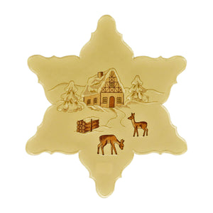 Star shaped cream color table linen, with a center design of a snow-covered chalet and trees, deer, and a bundle of wood.