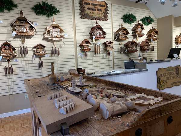 Authentic Black Forest cuckoo clocks displayed in the German Clocks & Gifts showroom, featuring handcrafted clock components