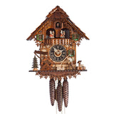 Image of a HÖNES 1-Day Chalet Cuckoo Clock depicting a wanderer hiking alongside a traditional half-timbered house, with green shutters, a mill wheel, and a well.