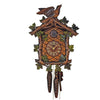 1-Day Schneider Traditional Black Forest Coocoo clock. The face of the brown clock is crosshatched. Delicately carved green vine leaves are growing around the edge of the clock. The dial in the middle has lighter colored Roman numerals and hands with a “Schneider” and “made in Germany” engraving. The door for the cuckoo bird above the dial has the initials “AS” carved on it. On top of the crown, a larger carved cuckoo bird is about to take flight with its beak half open.