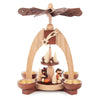 This beautiful, hand carved Christmas pyramid holds a candle on each of the sides of its base to provide gentle lighting on every side when in use. The heat from the candles causes the top propeller in the center of the pyramid to turn. There are trees and woodsmen who are carrying wood and knapsacks on the bottom main platform and smaller trees and mushrooms on the smaller upper platform.