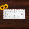 German embroidered table runner with mushroom and woodland design displayed on a dark wood table with sunflowers