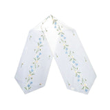 White linen table runner with spring flower embroidery, blue and white accents, with delicate cutout detailing, size 12.6x68 inches (32x173 cm).