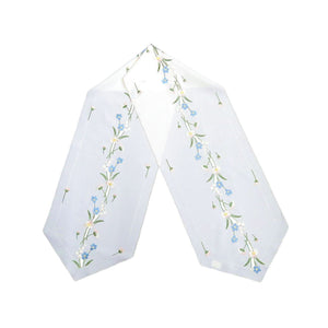 White linen table runner with spring flower embroidery, blue and white accents, with delicate cutout detailing, size 12.6x68 inches (32x173 cm).