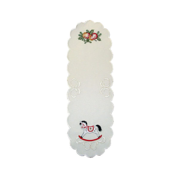 Cream rectangular table runner with a scalloped edge, featuring a red and black rocking horse design, with apples and holly as detailing.