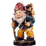 Hand-carved Wood Carrier Gnome by DEUR with walking stick, log bundle, and red hat, made in South Tyrol.