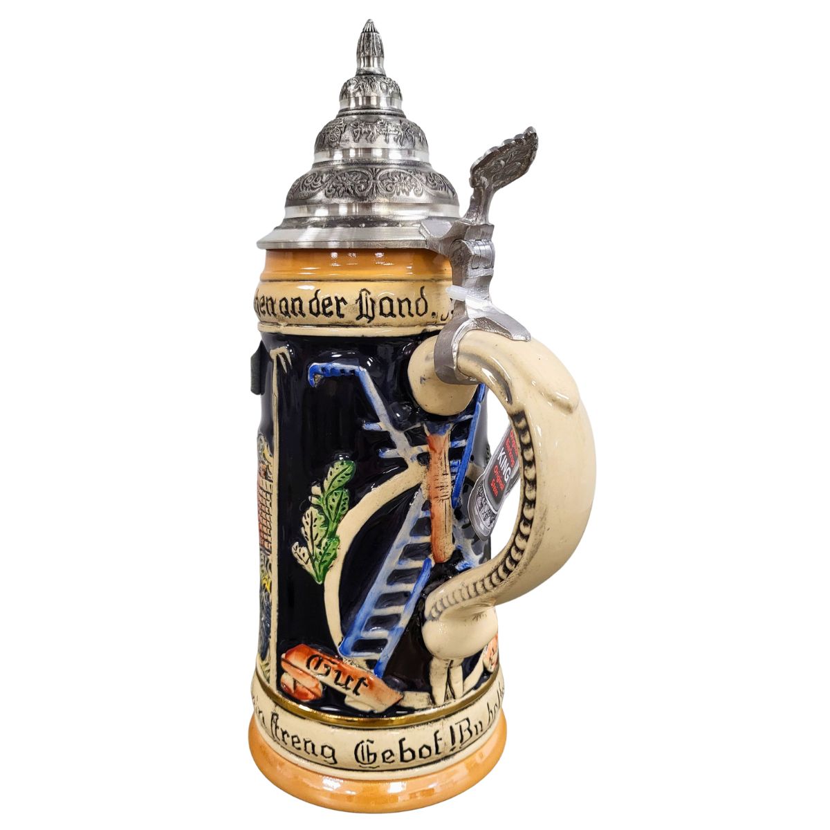 Side view of KING Fireman Beer Stein featuring ladder, axe, firefighting tools, German firefighter motto, and ornate pewter lid
