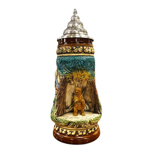 King Beer Stein with a cozy brown bear who stands in a grotto on a stone and observes its environment. The brown and green tones of the Mug underline the nature scenes.