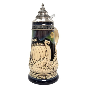 German beer stein with Viking ship, Norse warriors, runestone, village, and Northern Lights in blue and green colors, 0.5L.
