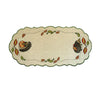 Sand color table runner, with a hedgehog on either side, with one on all fours, and the other holding an apple. A border of fall leaves blowing in the wind surrounds it.