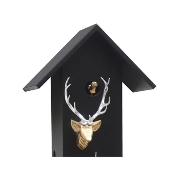 Close-up of CLASSIC black cuckoo clock showing carved stag head and visible cuckoo bird.