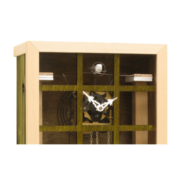Close-up of the green EINBLICK cuckoo clock, showing the glass panel, inner clockwork movement and cuckoo bird.