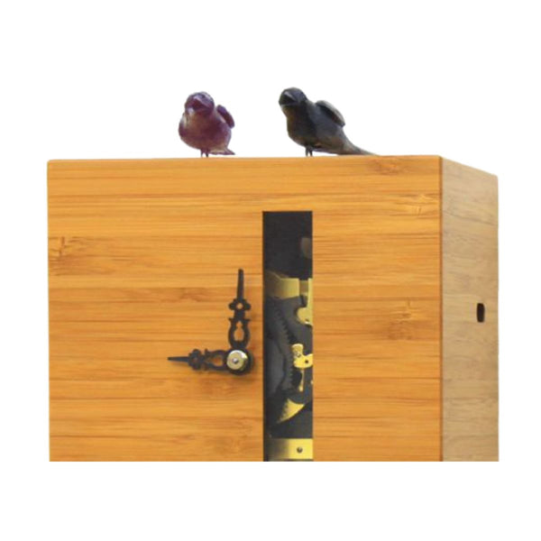 Close-up of DUETT bamboo cuckoo clock showing carved wooden birds and inner clock movement.