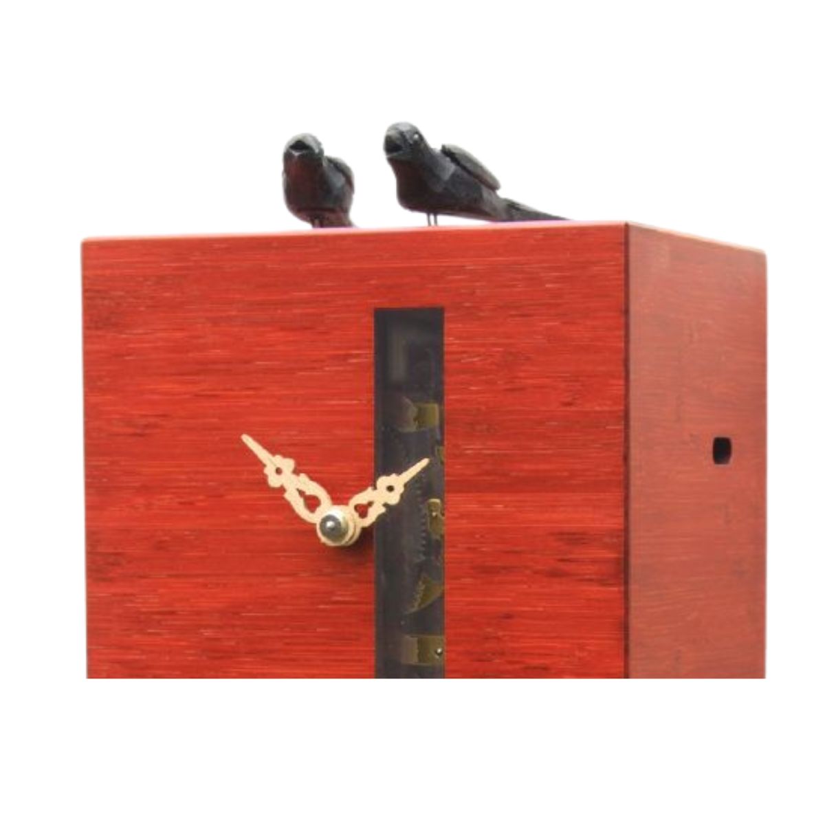 Close-up of DUETT red cuckoo clock showing visible mechanics and carved wooden birds.