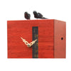 Close-up of DUETT red cuckoo clock showing visible mechanics and carved wooden birds.