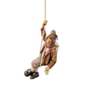 Carved wooden statue of a mountain climber, in traditional German mountain climber clothing and hat, holding a climbing rope.