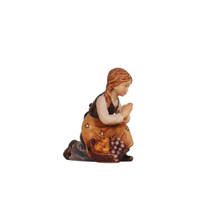 A PEMA Kostner kneeling girl figurine with hands in prayer and a basket of fruit, perfect for adding devotion and abundance to your holiday decorations
