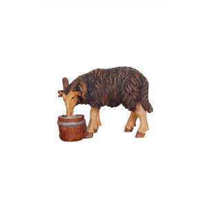 A beautifully carved white ram figurine with curly horns, looking left and eating from a wooden bucket, ideal for enhancing your holiday decor