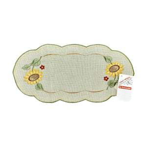 Sand color table runner with scalloped edges, with a border of sunflowers on either end of the runner.