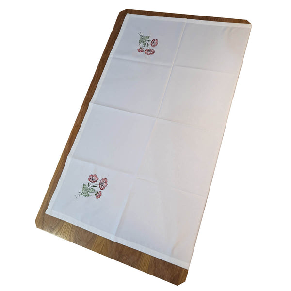Folded presentation of our elegant Poppy Bloom Table Cloth, featuring a trio of stunning poppy flowers in each corner. This vibrant addition brings a pop of color to your table setting, perfect for any occasion. Impress your guests with the elegant charm of this white cloth adorned with beautiful blooms.