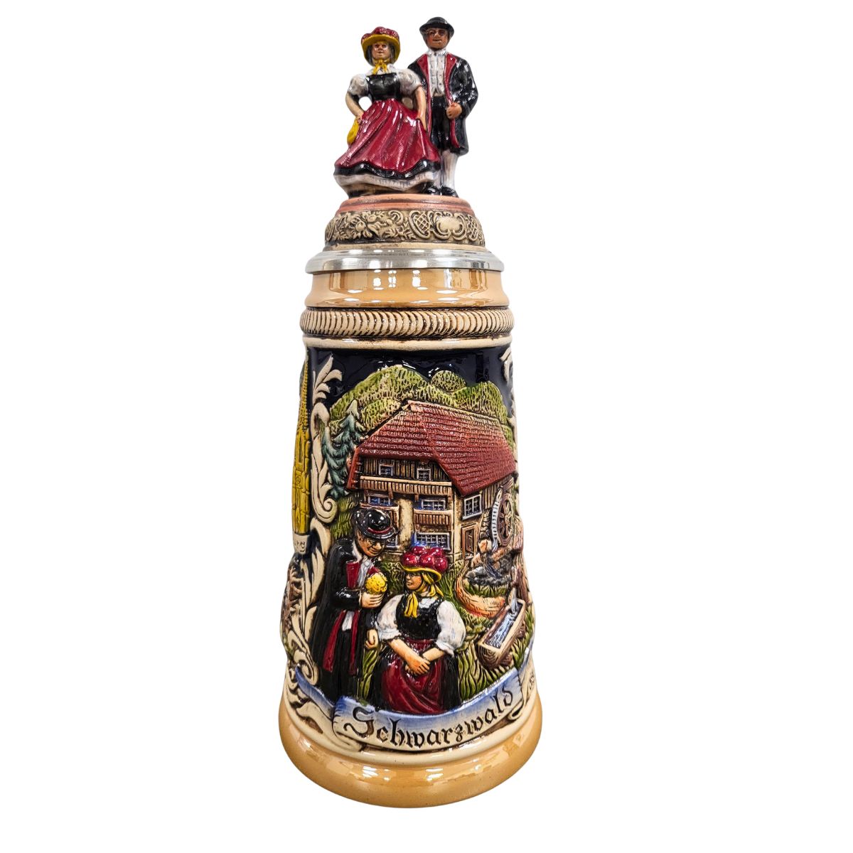 German Black Forest beer stein with raised relief landmarks and a ceramic lid topped with a traditional Schwarzwald couple.