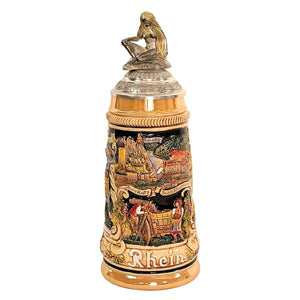 German beer stein with Loreley figurine lid, Rhine River panorama, castles, vineyard scene, white ship, and historic city names around the base.