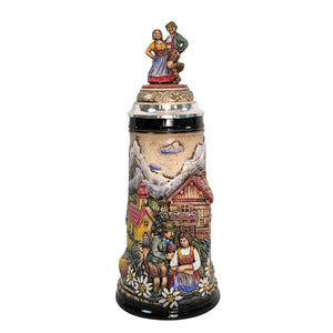 1-liter German beer stein with alpine couple, edelweiss flowers, mountain chalet, chapel, and pewter lid with dancing Bavarian figurines.

