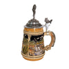 the side of a German beer stein with hand-painted fishing scene, fish-shaped handle, fish thumb lift, and pewter lid topped with a fisherman holding a catch.

