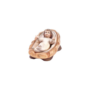 Sculpted wooden baby Jesus figurine for Artis Nativity set. He has his arms raised, while lying in a hay lined crib.