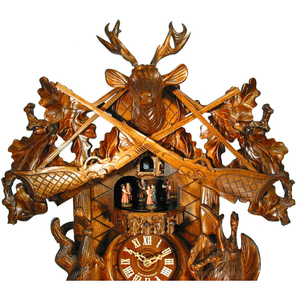Detail of the upper attachment of the August Schwer cuckoo clock with the two guns, the leaves and the deer head with antlers.