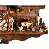 Detail view of Schwer cuckoo clock mill complex with farmer, cow and rooster in front of the cow barn