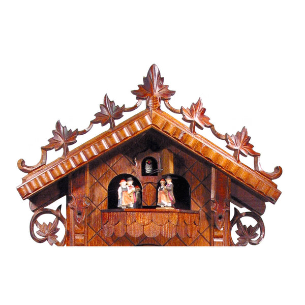 Close-up of the balcony on the 8-Day Station House Cuckoo Clock, showcasing the intricately designed cuckoo bird and spinning dancers dressed in traditional Black Forest attire, surrounded by decorative vine and leaf motifs.