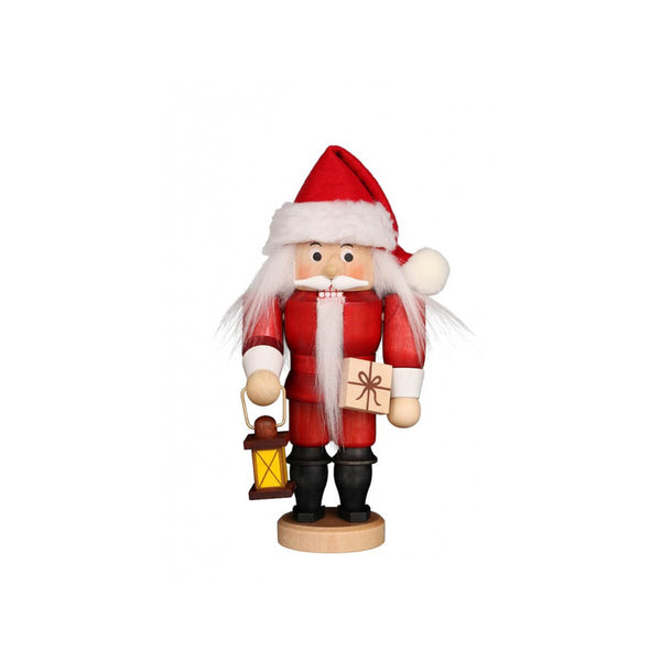 Small Christian Ulbricht Santa nutcracker with a long beard, a lantern and a wrapped gift. In his traditional red and white outfit he is ready to deliver the presents. 