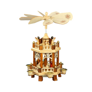 This natural-colored Pfaff Christmas pyramid is made out of wood and works with four pyramid candles. The two-tier pyramid shows the Nativity scene with Mary and Joseph and Baby Jesus in a manger on the first platform. Four winged angels are blowing their trumpets on the second platform. The laser-cut details include evergreen tree shaped fencing on the edge of both platforms and tear drop shaped decorations atop each fence post. The pyramid is 11.8 inches tall.