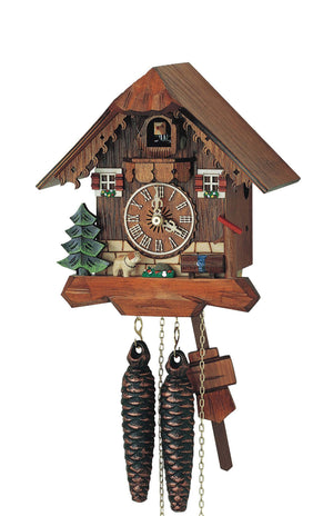 1-Day Schneider Chalet Coocoo clock with a St. Bernard dog next to an evergreen tree on the left. A water trough and pump sits on the right side of the clock. The lower part of the house is natural colored, and the wood paneling on the upper part is made in a darker stain. There are two windows with red shutters and window boxes on the upper level and the cuckoo door with the coocoo bird on the top in the middle. There is a decorative trim on the smooth roof.